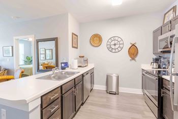 A kitchen with a white counter top and black cabinets.